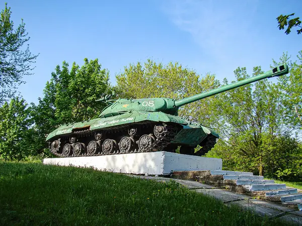 Beyaz bir platformda Sovyet döneminden kalma yeşil bir tankın açık hava görüntüsü, 01 'i de dahil olmak üzere kısmen görünür işaretler, arka planda ağaçlar, kapalı gün Kostiantynivka, Ukrayna, 06-15-2013