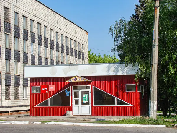 Kentsel bir ortamda yeşil bir çatıya kurulmuş küçük, kırmızı bir bina. Gündüz Kostiantynivka, Ukrayna, 06-15-2013 tarihlerinde hiçbir insan veya metin görünmüyor.