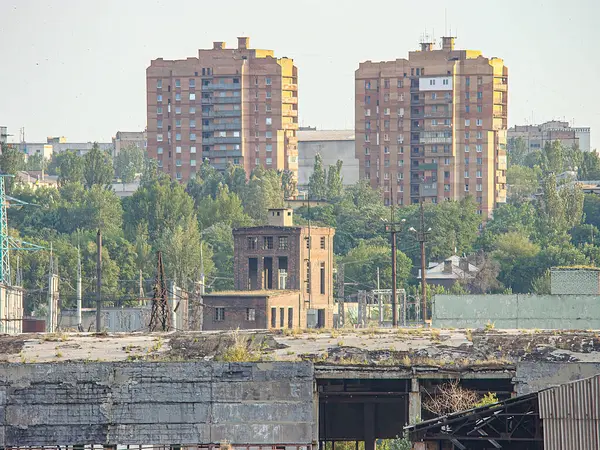 Kentsel manzaranın panoramik görüntüsü aşırı büyümüş çimenler, yapıların kalıntıları ve orta zemindeki belirgin tuğla bacası Uzak Kostiantynivka, Ukrayna, 06-15-2013