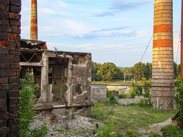 Üç farklı açıdan gösterilen bir endüstriyel binanın birleşik görüntüsü. Yapı, boyası soyulmuş, camları kırılmış ve Kostiantynivka, Ukrayna, 06-15-2013