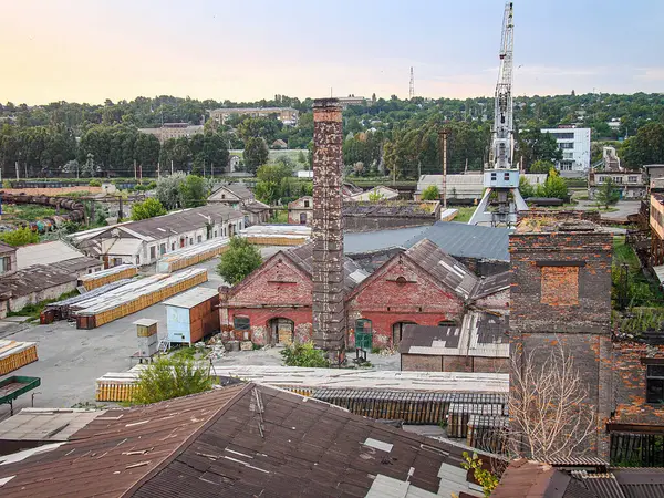 Tuğla ve metal binalar, açık bir alan, ağaçlar, bir kule ve bulutlar ile kırsal sanayi manzarası Coexis Kostiantynivka, Ukrayna, 06-15-2013