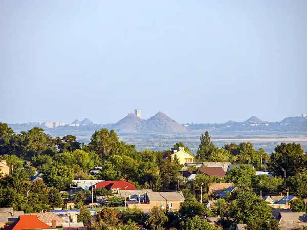 Yerleşim, ticari sanayi bölgeleri ve arka plandaki dağlarla karışık kentsel manzaralar sabahın erken saatlerinde veya geç saatlerde Kostiantynivka, Ukrayna, 06-15-2013