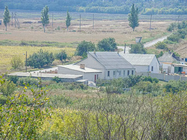 Küçük bir yerleşim yeri olan kırsal bir bölgede evler, ağaçlar yeşillik, açık arazi, yamaçsız dağlar ve açık gökyüzü Kostiantynivka, Ukrayna, 06-15-2013