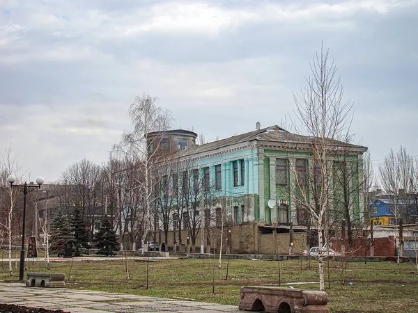 İki katlı bir bina yenileniyor, üst kısmı açık yeşil, alt kısmı ise aşınmış camlar, iskele iskelesi Kostiantynivka, Ukrayna, 06-15-2013