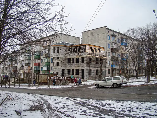 Kar yağışı devam eden bir sokak sahnesi, düşük çözünürlüklü görüntü, kentsel çevre, açık tuğla döşeme, ahşap iskele, mavi balkon korkulukları, Kostiantynivka, Ukrayna, 01-15-2013