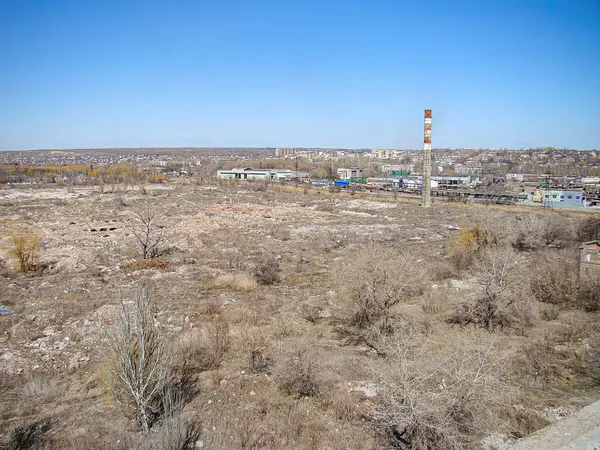 Terk edilmiş yapılara sahip sanayi manzarası, seyrek çayır ve çalılıklara karşı duruyor. Sahne, Kostiantynivka, Ukrayna, 06-15-2013 tarihindeki Kostiantynivka, Ukrayna 'yı ima eden insan ve hayvanlardan yoksun.