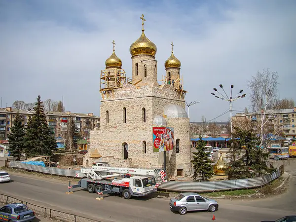 Birçok kubbe ve kulenin yer aldığı Bizans mimari tarzıyla süslü bir Hıristiyan kilisesi, yayalar ve park halindeki arabalarda bir Kostiantynivka, Ukrayna, 01-15-2013