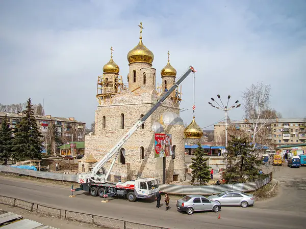 Görüntü birden fazla kubbesi olan dini bir bina gösteriyor, muhtemelen Ortodoks Hıristiyan. Başhekim Kostiantynivka, Ukrayna, 01-15-2013 için mavi bir kamyon ve vinç yakınlarda.