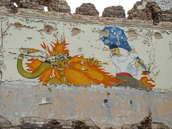 Kötüleşen bir duvardaki sokak sanatında iki zıt figür kılıçlı, ateşli bir yaratık ve şapkalı sakin bir insanımsı resim çizimi, Kostiantynivka, Ukrayna, 01-15-2013