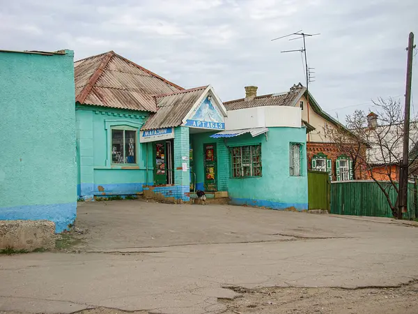 Görüntü, asfalt bir caddede, diğer binalar tarafından kısmen gizlenmiş iki renkli bir binayı tasvir ediyor. Gökyüzü ve yeşillik şehir sahnesine ekleniyor. Gizli sho Kostiantynivka, Ukrayna, 01-15-2013