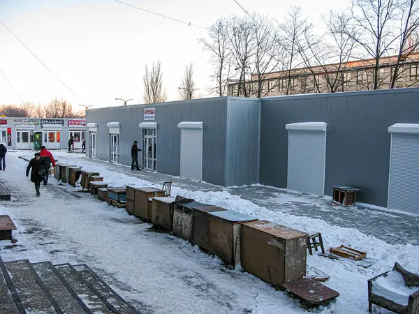 Kapalı dükkanlar, yerde kar, öğleden sonra üstü, bulutlu gökyüzü, yayalar, basit faytoncu binalar, olası ticari gelişmeler, Avrupalı- Kostiantynivka, Ukrayna, 01-15-2013