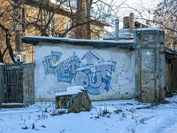 Eski ve yıkıcı sanayi bölgesinde karla kaplı zemin ve duvar yazısıyla süslenmiş kentsel kış manzarası. Kostiantynivka, Ukrayna, 01-15-2013