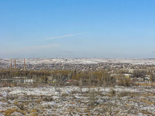 Engebeli arazi, dağınık ağaçlar, geniş tarlalar ve uzak insan yerleşimine sahip karla kaplı bir manzara Kostiantynivka, Ukrayna, 01-15-2013