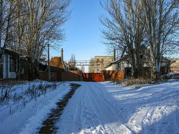 Bir patika, ayak izleri, yapraksız bitki örtüsü, iki bina ve Kostiantynivka, Ukrayna, 01-15-2013