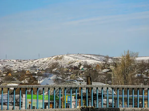 Tamamlanmamış yapısı, muhtemel demiryolu üstgeçidi, karışık kullanım alanları olan binalar, kar yağışı, açık mavi gökyüzü, doğal Kostiantynivka, Ukrayna, 01-15-2013
