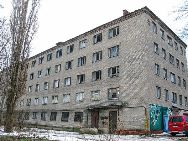 20. yüzyılın ortalarında tuğla duvarları, üst katlarda balkonları, rampası ya da basamakları olan bir giriş, zeminde kar, bulutlu gökyüzü ve yapraklı Kostiantynivka, Ukrayna, 01-15-2013