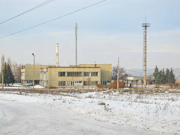 Görüntü, kar ve solunda çıplak ağaçlar olan büyük bir sanayi fabrikası deposunu ve kar ve daha açık alanda Kostiantynivka, Ukrayna, 01-15-2013