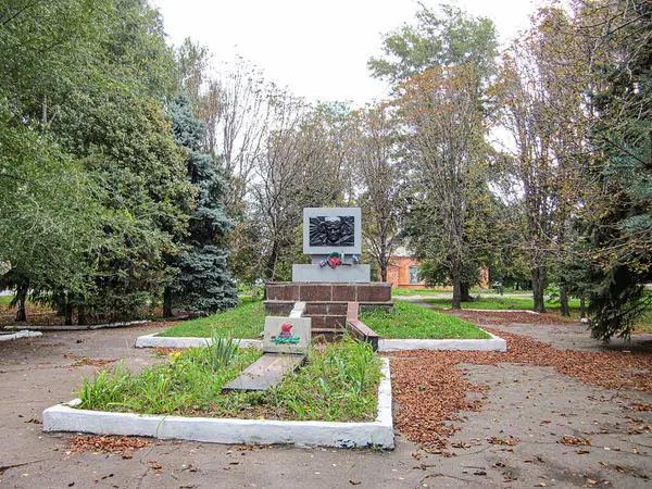 Uzun, çok katmanlı bir anıt ya da anıt, düzgün kesilmiş çimenler ve düşmüş yapraklarla bir park ortamının ortasında duruyor. Yapının Kostiantynivka, Ukrayna 'da iki alt plaketi var, 06-15-2013