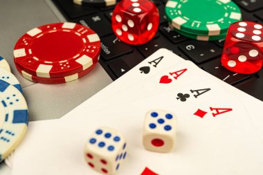 Kumar eşyalarının yakın plan görüntüsü. Kağıt, zar ve poker fişleri. Arka planda bulanıklık var.