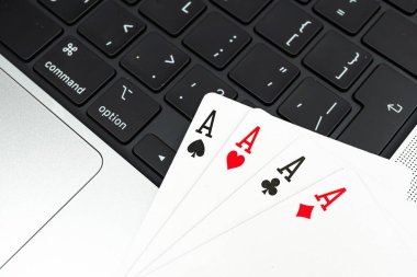 Dizüstü bilgisayarda kart oynarken, Aces ve Maça Papazının pokerde floş yaptığını gösteren yakın plan görüntü teknoloji, oyun ve stratejik düşünme içeriyor.