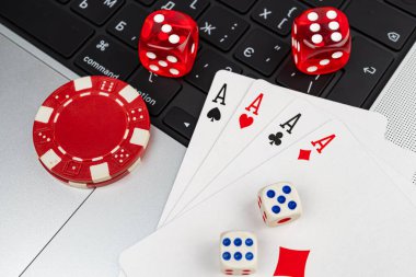 Kumar oynayan kumarbazların yakın plan görüntüsü maça ası, as, kumarhane çipleri, Bet tuşlu bilgisayar klavyesi ve sıklıkla heyecan ve rastgelelik içeren dağınık bir düzen.