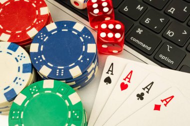 Oyun masasında poker çiplerinin yakın plan çekimi, Maça Ası, blackjack ya da poker, arka planda bilgisayar klavyesi ile çağdaş ayar, şans, strateji ve kumar temaları çağrıştıran