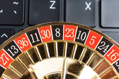 Yüksek çözünürlüklü bir resimde 12 numaralı rulet tekerleği gösteriliyor. Altınla detaylandırılmış. Bulanık teknoloji arka planına karşı klasik kırmızı ve siyah bir düzen var.