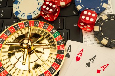 Rulet çarkını içeren canlı bir kolaj, kraliyet floşları ve çeşitli eyaletlerdeki zarları içeren dağınık iskambil kağıtları. Görüntü heyecan ve kumarhane oyunlarının cazibesini gösteriyor.