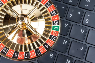 Çevrimiçi ya da dijital bağlamda, muhtemelen kumarhane reklamlarında ya da risk uygulamalarında kullanılan top çevirmeli altın rulet çarkının yakın plan görüntüsü.