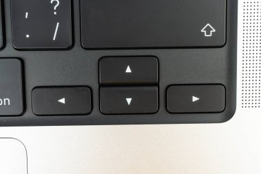 Görüntü dizüstü bilgisayarın yön anahtarlarının yakın çekimini gösterir. Üst, alt, sol, sağ ve bilgisayar ekranları içinde gezinmedeki rolleri