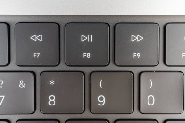 Bir dizüstü bilgisayarın 7-0 tuşlarına odaklanan yakın plan resmi, artı pazarlama malzemeleri veya ürün listeleri için sıfırın üzerinde nötr arkaplan