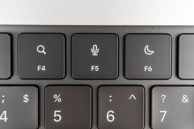 Resim, fonksiyon tuşlarına ve sayısal tuş takımına odaklanmış, dizüstü bilgisayarda biraz yükseltilmiş bir klavye gösterir. Bu, mantarı vurgulamak için ürün fotoğrafçılığında aşınma veya ergonomik tasarım önerebilir.