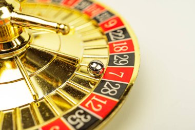 Kırmızı ve siyah sayılarla dönen bir altın rulet çarkı, hareket halindeki gümüş top heyecan ve kumar beklentisini yakalar.