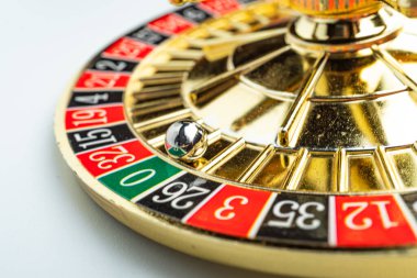 Altın tonlu rulet çarkı hareket ediyor. Alternatif siyah ve kırmızı sayılar var. Oyun sonucu için bir deliğe düşmeden önce beyaz top dönüyor.