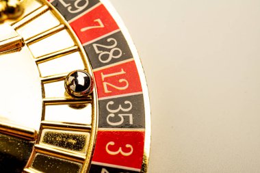 Üç numarada dönen altın rulet çarkının görüntüsü, kumar ve eğlencenin lüksünü ve heyecanını simgeliyor.