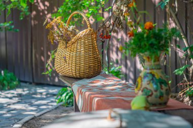 Bereketli yeşilliklerle çevrili, dokuma sepetli ve masa örtülü sakin bir açık hava sahnesi rahatlamayı, doğal güzelliği ve açık hava yaşam alanlarını öneriyor.