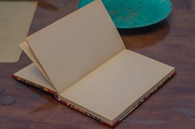 Resim, planlama, hikaye anlatma, yaratıcılık, klasik ve Mark 'a uygun zamansız kalite temaları ile, kullanıma hazırlık veya potansiyeli sembolize eden, eski ahşap yüzey üzerine açık bir defter içeriyor.
