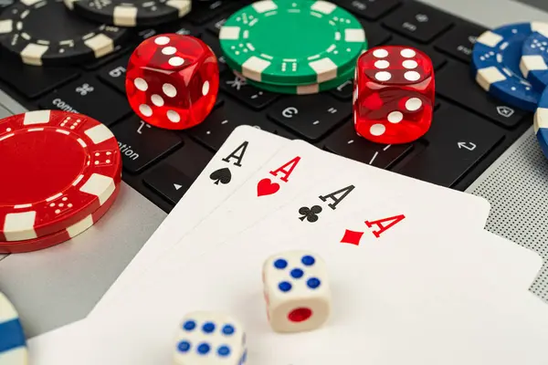 Poker çipleri ve bir ev ortamında dizüstü bilgisayarda canlı bir kumarhane arayüzü olan bir stok görüntüsü oyun ve teknik unsurlar sergiliyor.