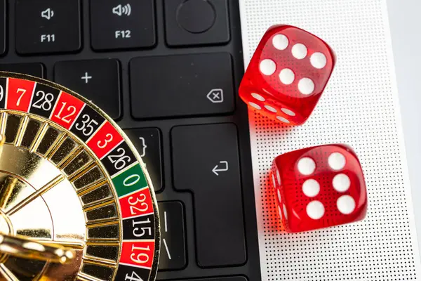 Görüntü, kumarhane arayüzünü gösteren bir dizüstü bilgisayarla çevrimiçi bir kumar sahnesini tasvir ediyor, zar gibi zar ve klavye dijital ve klavye arasındaki etkileşimi sembolize ediyor.