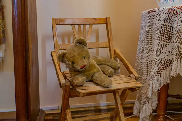 Görüntü, eski moda sallanan sandalyesi ve gevşek doldurulmuş aslan pelüşlü oyuncağıyla rahat, nostalji ve pazarlamaya uygunluğu çağrıştıran samimi bir sahne gösteriyor.