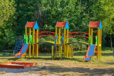 Parkta oynayan açık hava çocukları için ilgi çekici ekipmanlarla dolu bir oyun parkı.