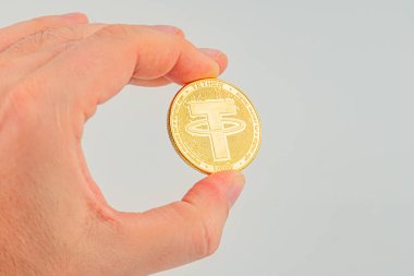 Bir el düz bir arkaplana karşı bir bağlantı madeni para tutar, kripto para bağlama zenginlik veya yatırım sembolize