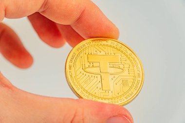 Resim, karmaşık devre şablonları olan bir el tarafından tutulan ve kripto para ve engelleme teknolojisi bağını göstermek için kullanılan bir bozuk parayı gösteriyor.