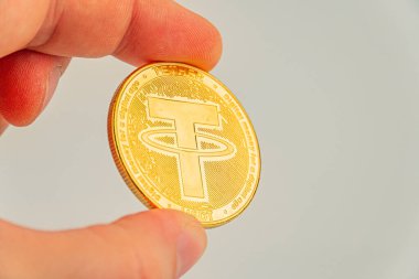 Görüntü, kripto, engelleme zinciri ve finansal yenilik testeresi ile ilgili pazarlama materyalleri için kullanışlı olan kripto para biriminin ilk günlerini sembolize eden fiziksel bir bağlayıcı para jetonunu tutan bir eli gösteriyor.