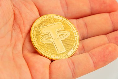 Dijital para birimini ya da engelleme teknolojisini temsil eden bir eldeki bağlanmış madeni paranın yakın plan fotoğrafı.