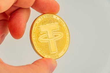 Altın renkli bir paranın yakın plan görüntüsü, değeri, kıtlığı ve kripto para bağlayıcı potansiyel yatırımı sembolize ediyor.