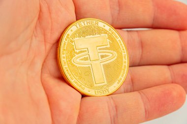 Bir el, madeni etkisini sembolize eden bir parayı tutar.