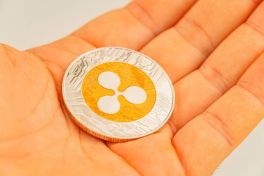 QR kodlu küçük bir kripto para tutan bir el resmi, dijital kimliği ya da engelleme teknolojisi içindeki değer değişimini simgeliyor.