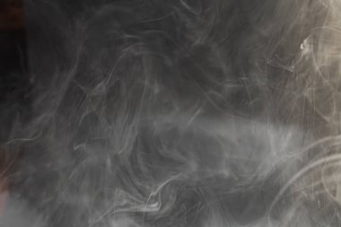 Değişimi, geçişi, özgürlüğü, fikirlerin akıcılığını ve geçici doğayı sembolize eden, serin renklerle dönen duman veya buharın dinamik ve soyut bir görüntüsü.