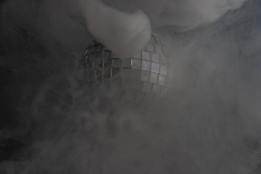 Puslu, puslu bir ortamda parlayan bir disko topuyla dramatik bir sahne dönüşümü ya da yeniliği simgeliyor.